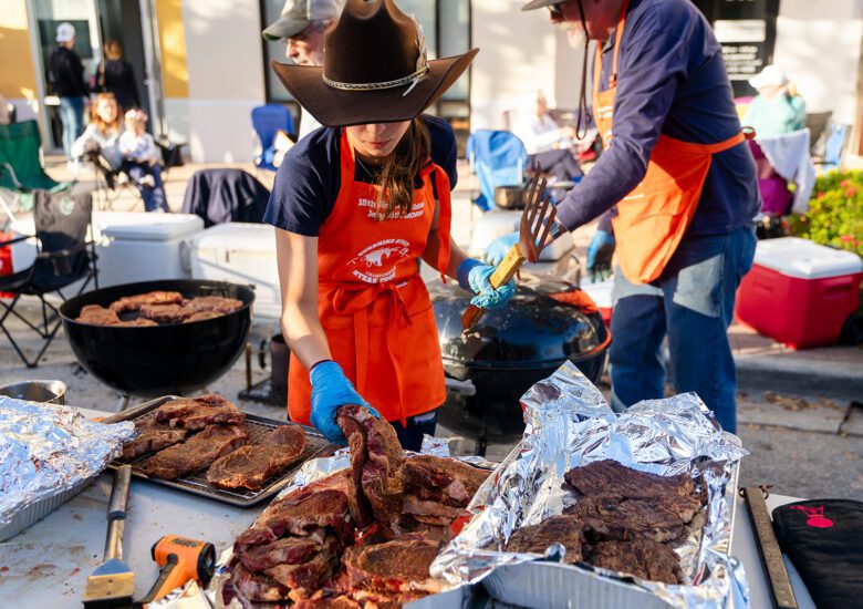 Participating grill team seasons steaks at 2025 Sunshine State Steak Cook-Off