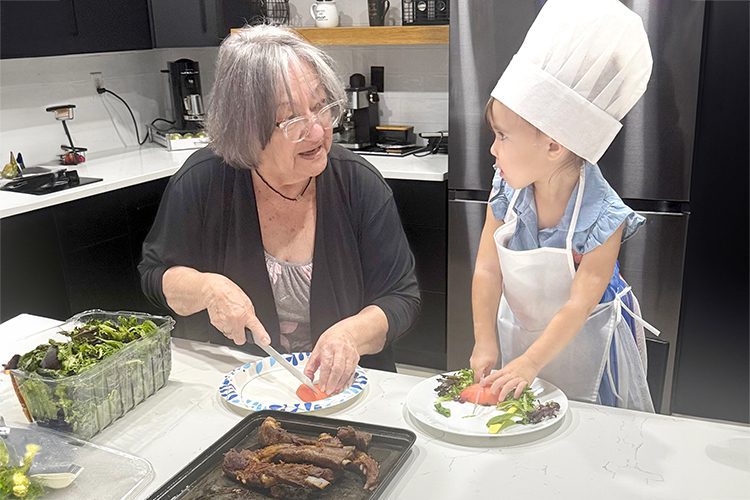 Esperanza Meléndez teaches her great-granddaughter Camila how to make salads.